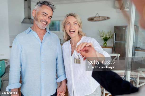 real estate agent giving a mature couple the key to their new house. - apartment australia bildbanksfoton och bilder