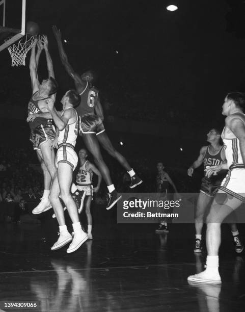 Vying for this rebound in the first quarter of the fourth game of the NBA championship series are left to right: Tom Heinsohn Celtics, Bob Petit...