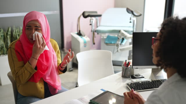 무슬림 여성이 나쁜 건강 결과로 인해 산부인과 전문의 사무실에서 울고 있습니다.