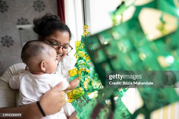 teenager girl carries niece while looking at decorations - indian aunt stock pictures, royalty-free photos & images