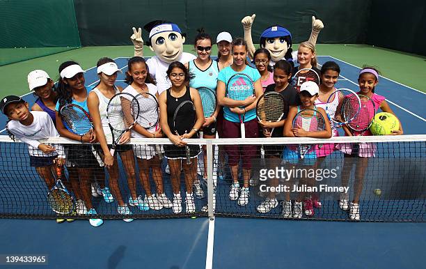Flavia Pennetta of Italy and Abigail Spears of USA pose with children after their kids clinic during day two of the WTA Dubai Duty Free Tennis...