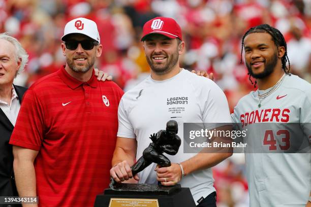 Quarterback Baker Mayfield of the Oklahoma Sooners holds his Heisman Trophy with former Heisman winners Steve Owens, Jason White, and Kyler Murray...