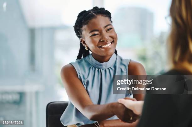 joven empresaria africana segura de sí misma estrechando la mano de un colega en una oficina - interview fotografías e imágenes de stock