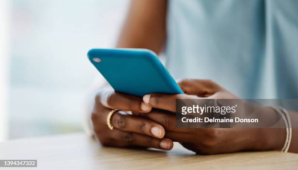 femme africaine utilisant un téléphone portable dans un bureau seule - smartphone woman photos et images de collection