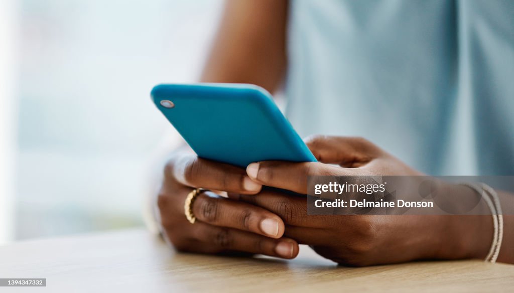 African woman using a cellphone in an office alone