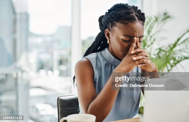 stressed black businesswoman working on a laptop in an office alone - expression stress stockfoto's en -beelden