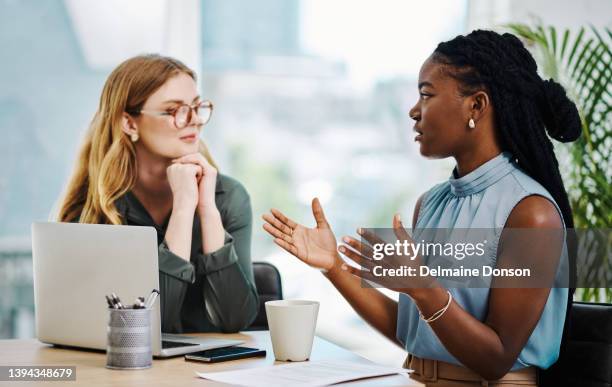 two diverse businesswomen having a discussion to share ideas and plans while working together in an office - hr stock pictures, royalty-free photos & images