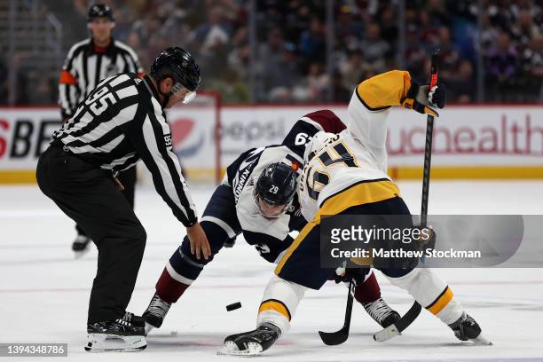 Nathan MacKinnon of the Colorado Avalanche faces off against Mikael Granlund of the Nashville Predators in the overtime at Ball Arena on April 28,...