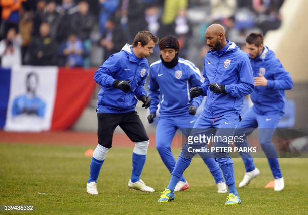 French striker Nicolas Anelka warms up with teammates before his team Shanghai Shenhua play in a friendly match against Hunan Xiangtao at their...