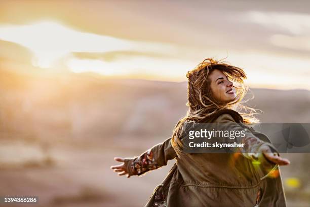 carefree woman spinning in autumn at sunset. - woman twirling stockfoto's en -beelden