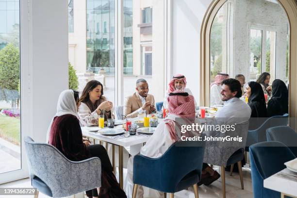 business team enjoying lunch break in riyadh restaurant - saudi lunch stock pictures, royalty-free photos & images