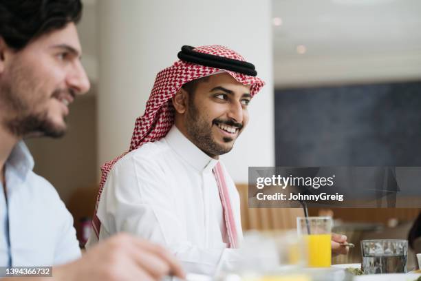 young saudi businessmen enjoying conversation over lunch - saudi lunch stock pictures, royalty-free photos & images