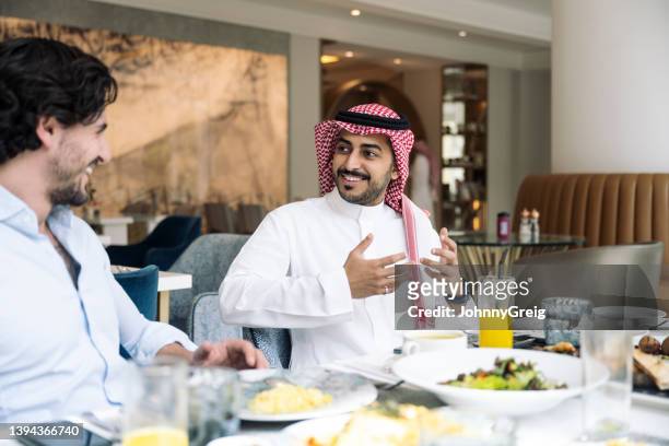 middle eastern business associates enjoying lunch together - saudi relaxing stock pictures, royalty-free photos & images