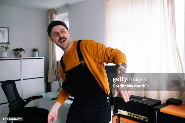 happy man dancing in home studio - cantar fotografías e imágenes de stock