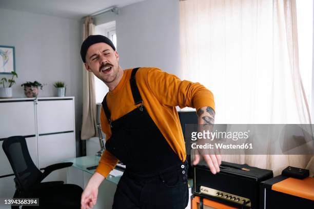 happy man dancing in home studio - man singing stockfoto's en -beelden
