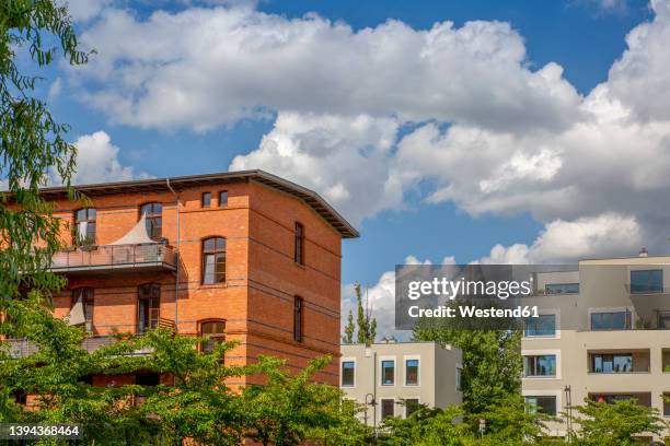 germany, berlin, clouds over modern apartment buildings in new development area - berlin modernism housing estates stock pictures, royalty-free photos & images