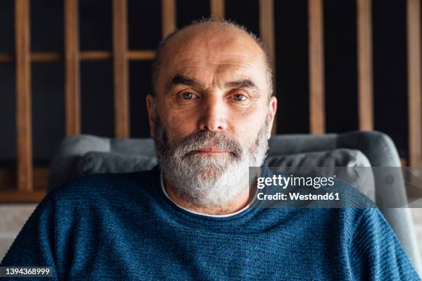 senior man with beard sitting at home - baby boomer fotografías e imágenes de stock