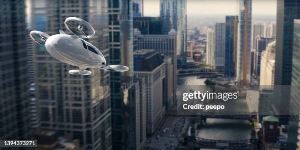 evtol avion électrique à décollage et atterrissage verticaux volant à travers des gratte-ciel - hélicoptère ville photos et images de collection