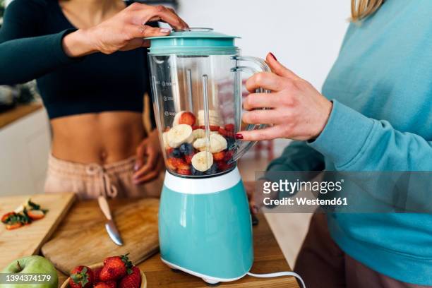 friends blending fruits in blender at home - blended drink stock pictures, royalty-free photos & images