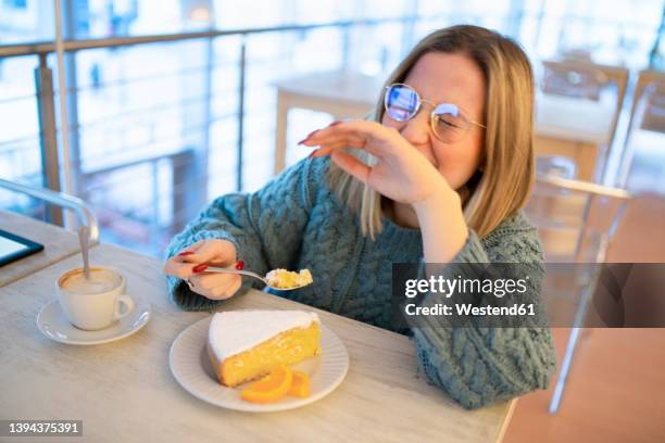 happy young woman enjoying lemon cake at table - lemon cake stock pictures, royalty-free photos & images