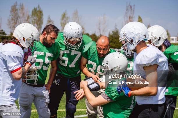 football  team captain going over play to football players - college sports team stock pictures, royalty-free photos & images