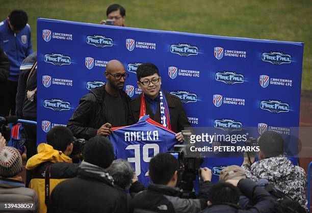 French striker Nicolas Anelka poses with a fan after his team Shanghai Shenhua played a friendly match against Hunan Xiangtao at their training...
