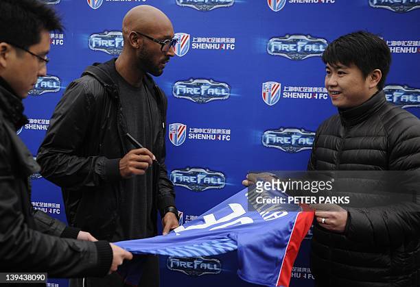 French striker Nicolas Anelka signs an autograph for a fan after his team Shanghai Shenhua played a friendly match against Hunan Xiangtao at their...