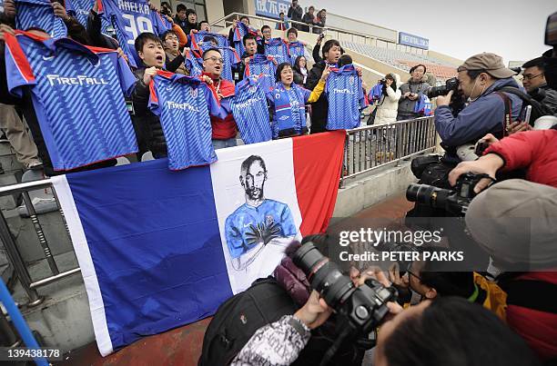 Fans of French striker Nicolas Anelka pose for photos after his team Shanghai Shenhua played a friendly match against Hunan Xiangtao at their...