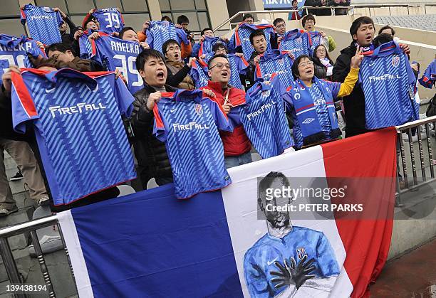 Fans of French striker Nicolas Anelka sing after his team Shanghai Shenhua played a friendly match against Hunan Xiangtao at their training ground in...