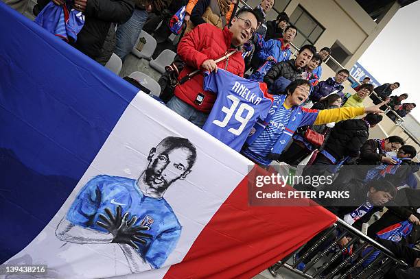 Fans of French striker Nicolas Anelka sing after his team Shanghai Shenhua played a friendly match against Hunan Xiangtao at their training ground in...