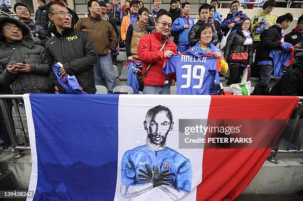 Fans of French striker Nicolas Anelka sing after his team Shanghai Shenhua played a friendly match against Hunan Xiangtao at their training ground in...