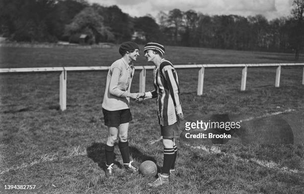 The two team captains, Madeleine Bracquemond of the French women's soccer team, and Alice Kell of Dick, Kerr Ladies F.C representing England, shake...