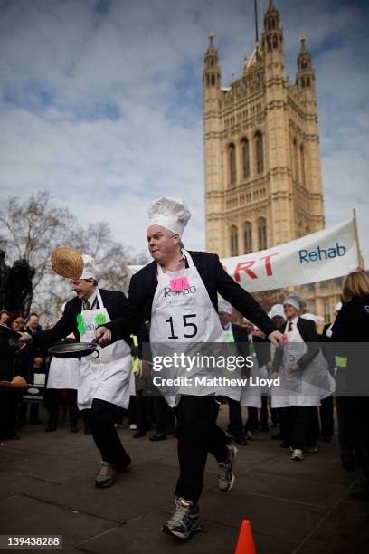 Sky News presenter Adam Boulton leads from the start line of the Annual Rehab Parliamentary Pancake Race on February 21, 2012 in London, England. Now...