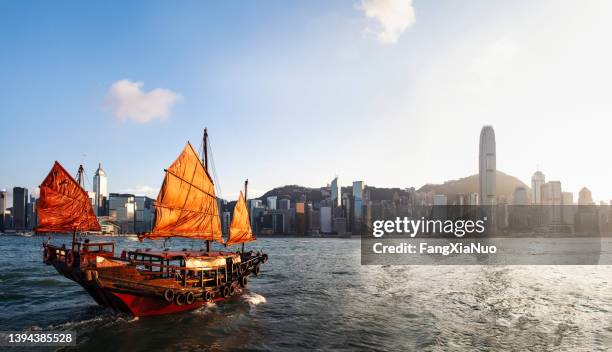 hongkongs victoria harbor mit traditionellem rotem segel-junk-boot - hong kong junk boat stock-fotos und bilder