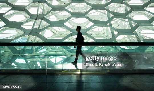 Man walking alone in modern corridor hallway Man walking alone in modern corridor hallway