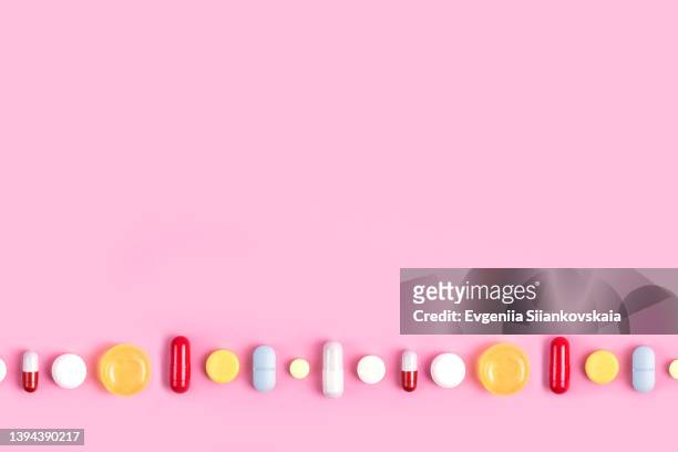 different pills on pink background. close-up. - vitamin b stockfoto's en -beelden