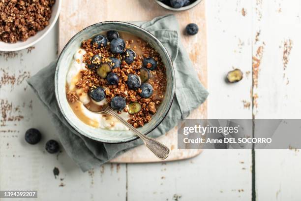 breakfast granola bowl with blueberries and yogurt - cereal overhead stock-fotos und bilder