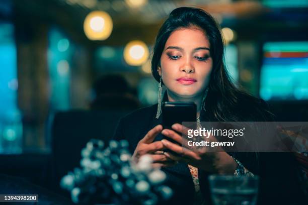 businesswoman relaxes and uses a smartphone in a restaurant. - focus lens stockfoto's en -beelden
