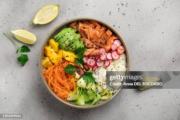 poke bowl with salmon rice avocado mango lemon salad carrots vegetables - bowl of rice stockfoto's en -beelden