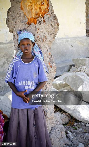 Young girl watches an AMISOM patrol pass the village of Jamuhuria on February 20, 2012 in Mogadishu, Somalia. As operations against Al Shabaab...