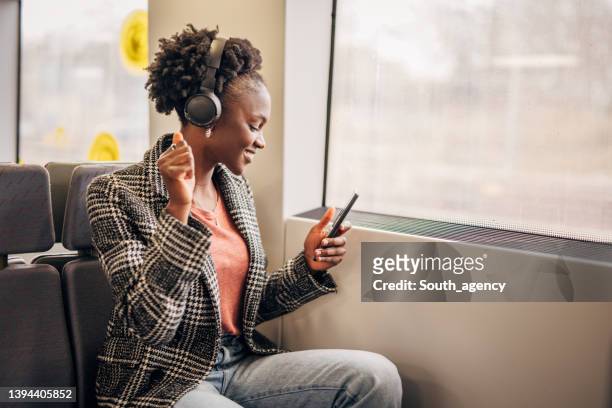 jovem no metrô trem ouvindo música no celular - beautiful south african women - fotografias e filmes do acervo