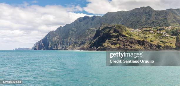 panorama of mountains plunging into the sea at porto da cruz - borde del agua fotografías e imágenes de stock