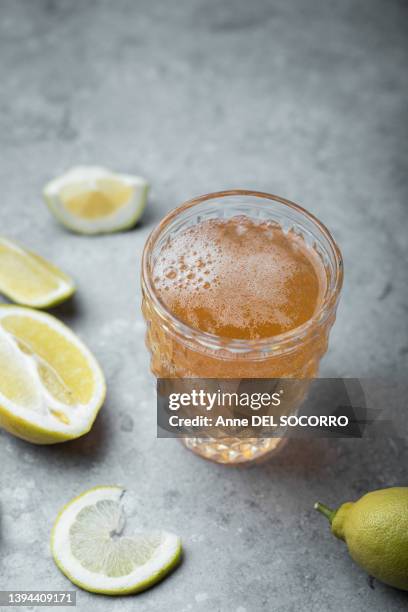 fresh kombucha sparkling drink in a glass with lemon - kombucha stockfoto's en -beelden