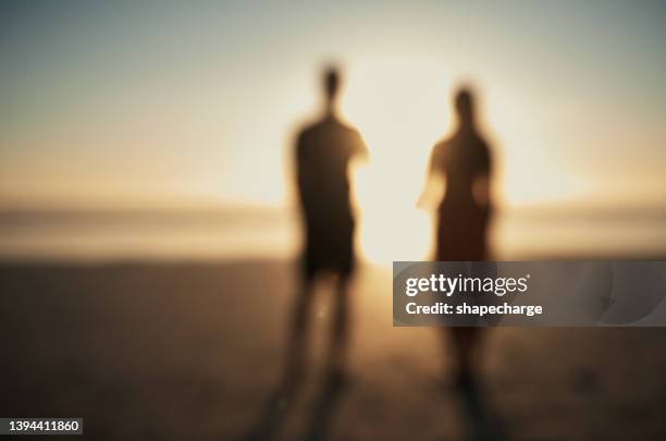 two blurry people couple standing watching the sunset sunrise on holiday at the beach - bf 2019 stock pictures, royalty-free photos & images