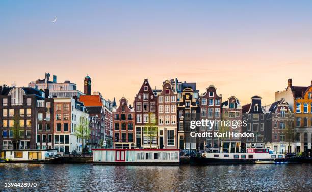 a surface level sunrise view of amsterdam at dawn - amsterdam stockfoto's en -beelden