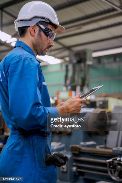 blue collar worker with co worker at factory. - engineer gearwheel factory stockfoto's en -beelden