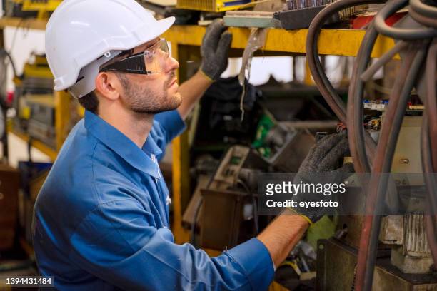 blue collar worker with co worker at factory. - engineer gearwheel factory stockfoto's en -beelden