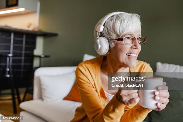 portrait of a senior woman enjoying at home - people podcasting stock pictures, royalty-free photos & images