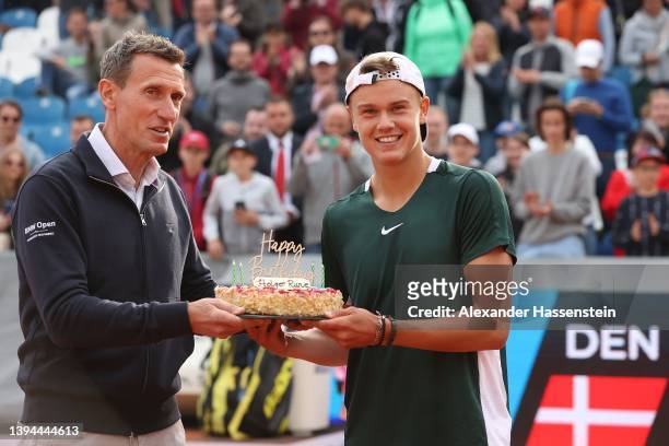 Holger Rune of Denmark receives a birthday cake for his 19th birthday from Tournament director Patrik Kühnen after winning his quater-finale match...