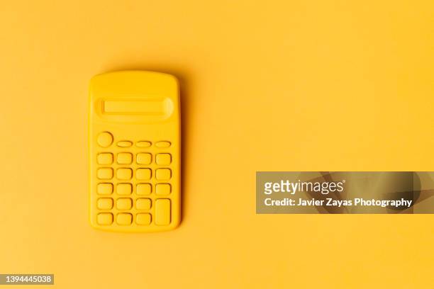 yellow calculator on yellow background - calculator top view stock-fotos und bilder